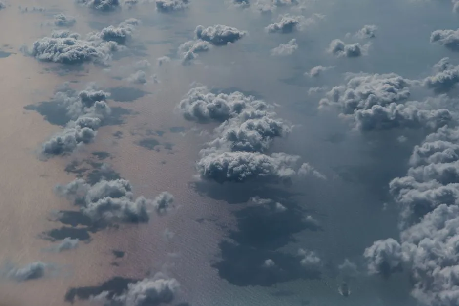 Scattered cumulus clouds seen from above, the kind that block optical satellite views of a field
