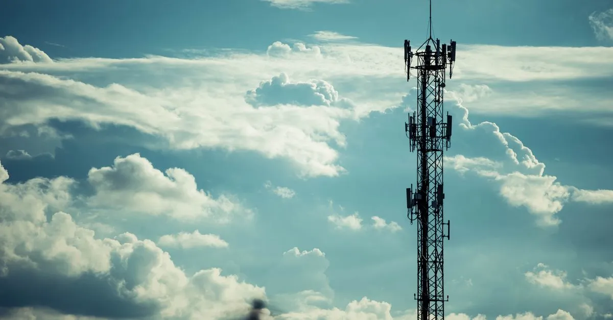 An antenna mast against the sky, evoking the reference station whose distance sets the RTK baseline